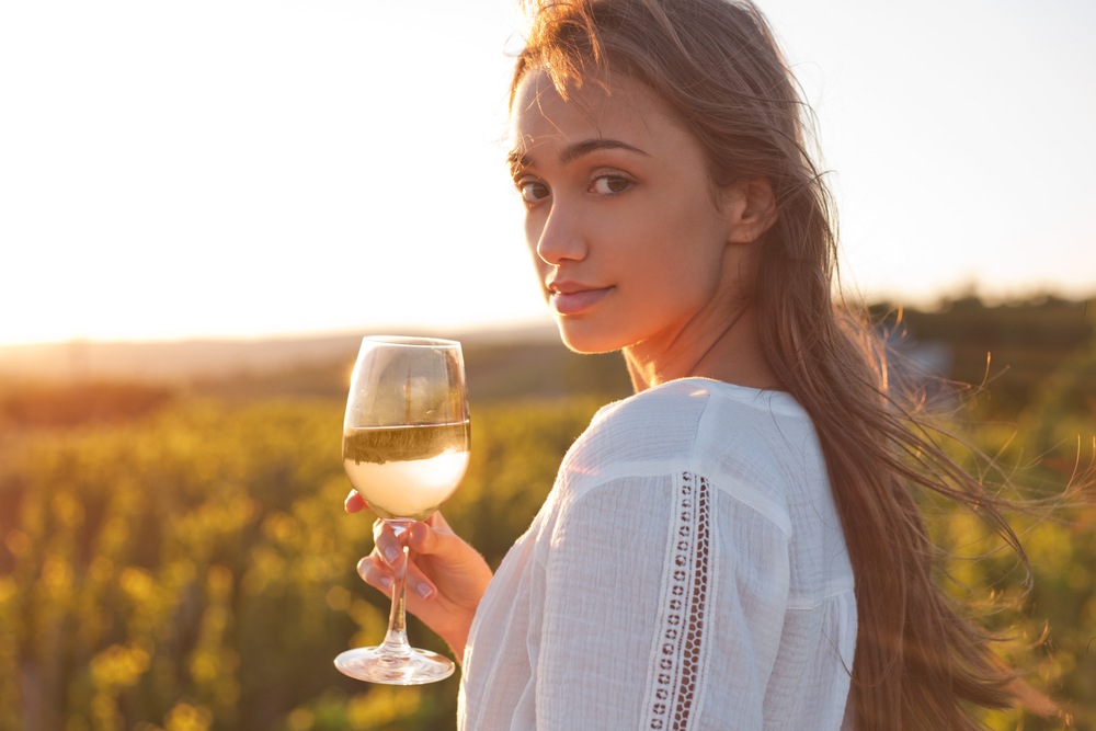 jeune femme avec un verre de vin blanc